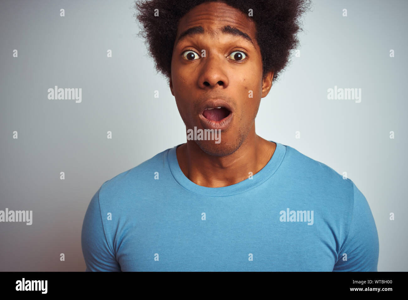 African American Man With Afro Hair Wearing Blue T Shirt Standing