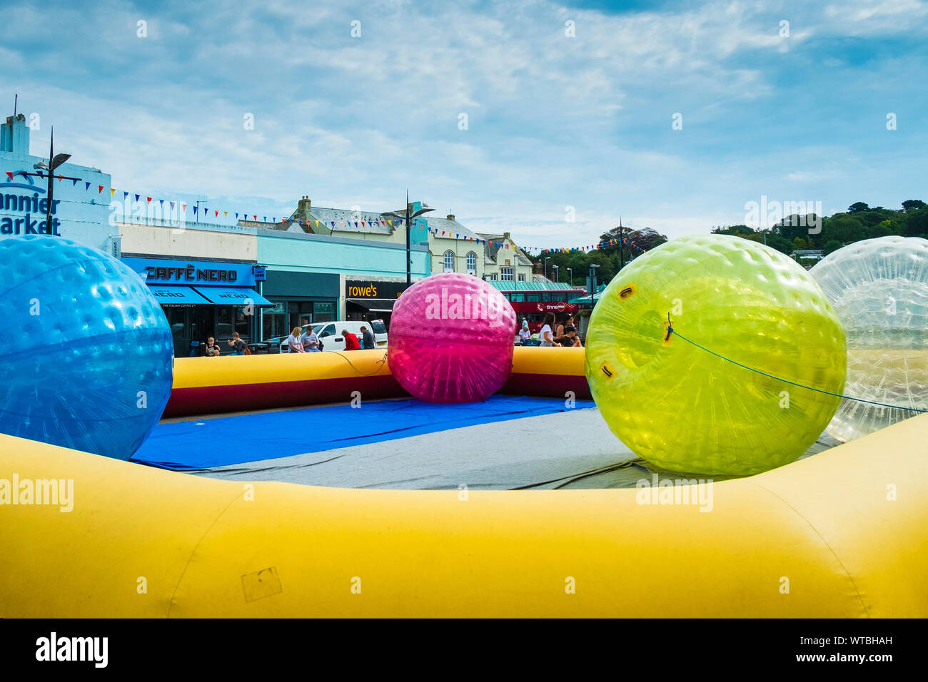 Zorbing.  Zorb balls with a massive inflatable surround erected in Lemon Quay in Truro City centre in Cornwall. Stock Photo