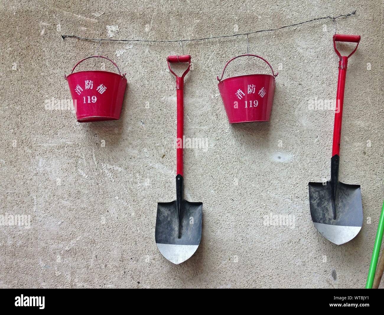 Red Bucket With Shovels Hanging On Wall Stock Photo Alamy