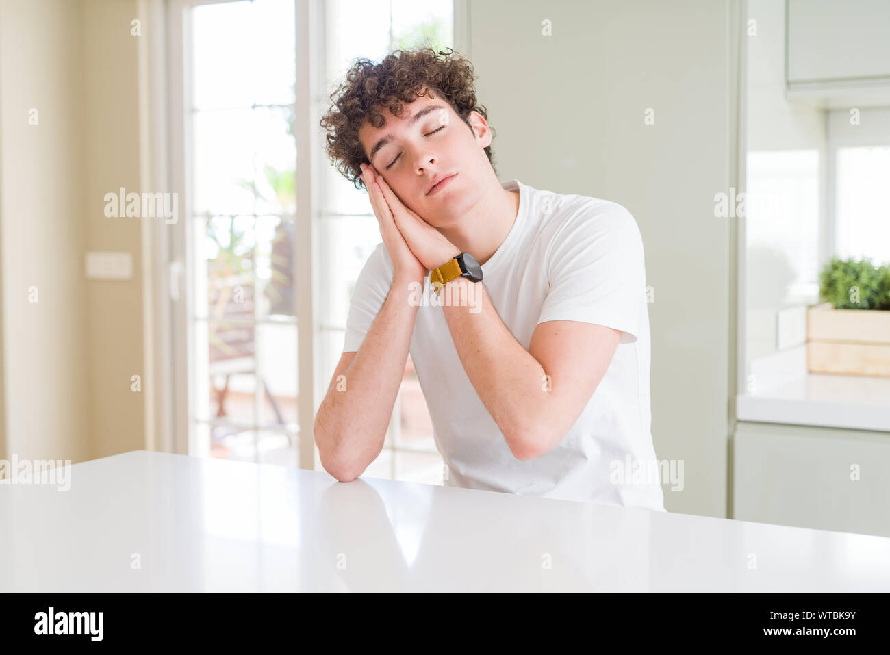 Young handsome man wearing white t-shirt at home sleeping tired ...