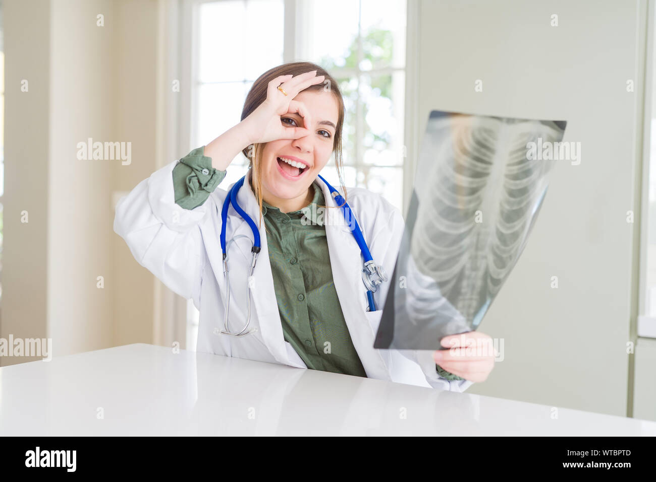 Beautiful young doctor woman looking at chest radiography with happy ...