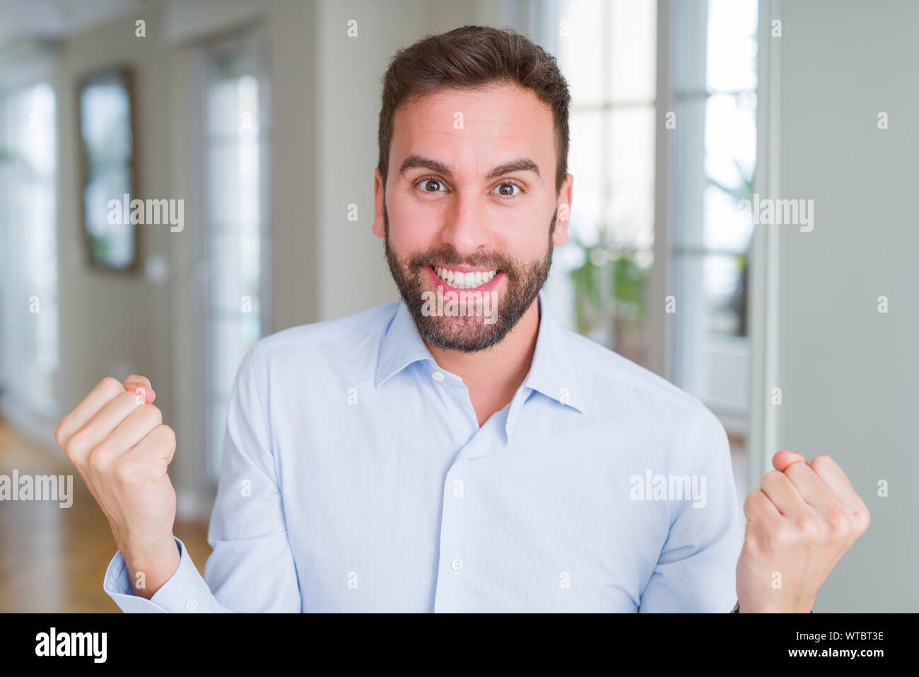 Handsome business man celebrating surprised and amazed for success with ...