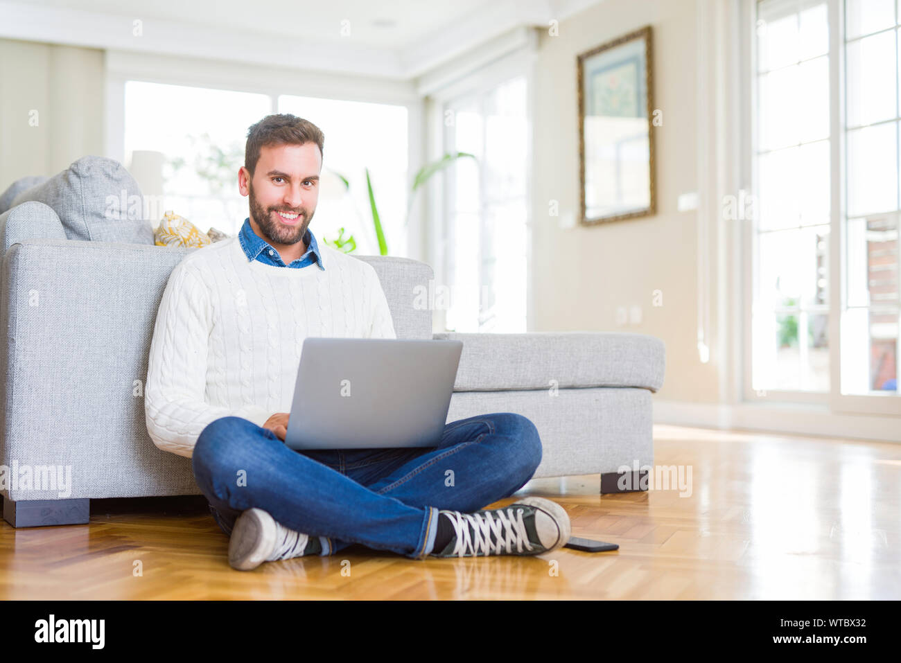 Handsome man wearing working using computer laptop with a happy face ...