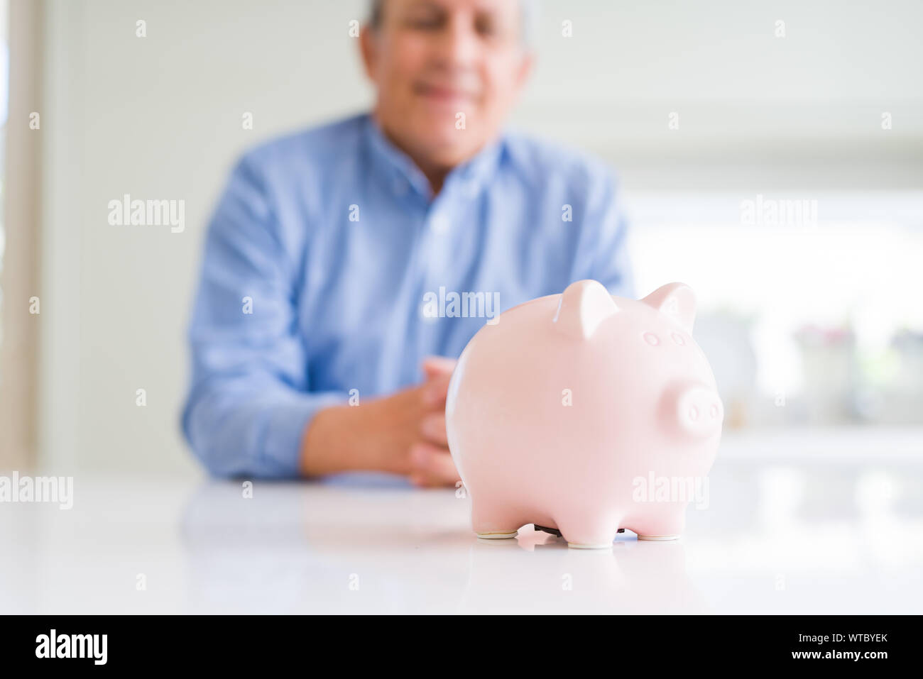 Close up of piggy bank and man smiling at the background Stock Photo ...