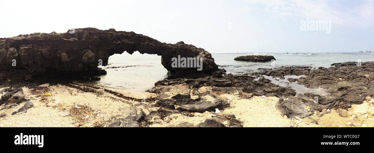 Natural Rock Arch At Beach Stock Photo