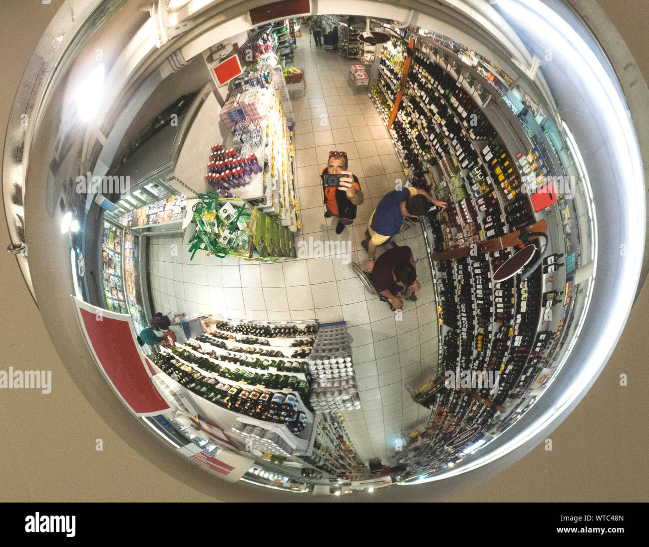 Reflection Of Man Photographing With Smart Phone In Super Market Stock Photo