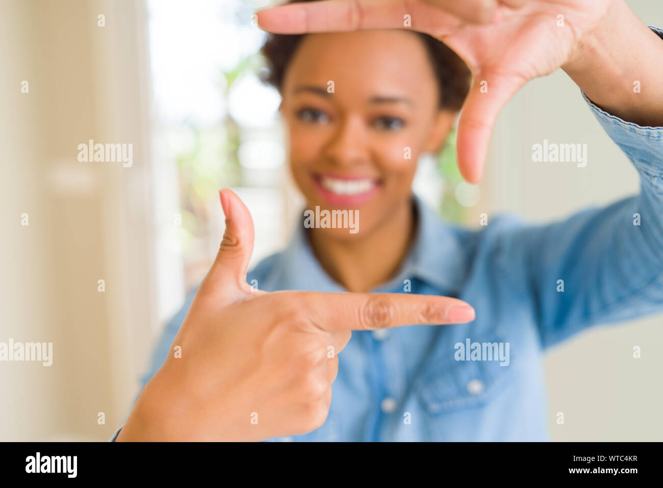 Young beautiful african american woman smiling making frame with hands ...