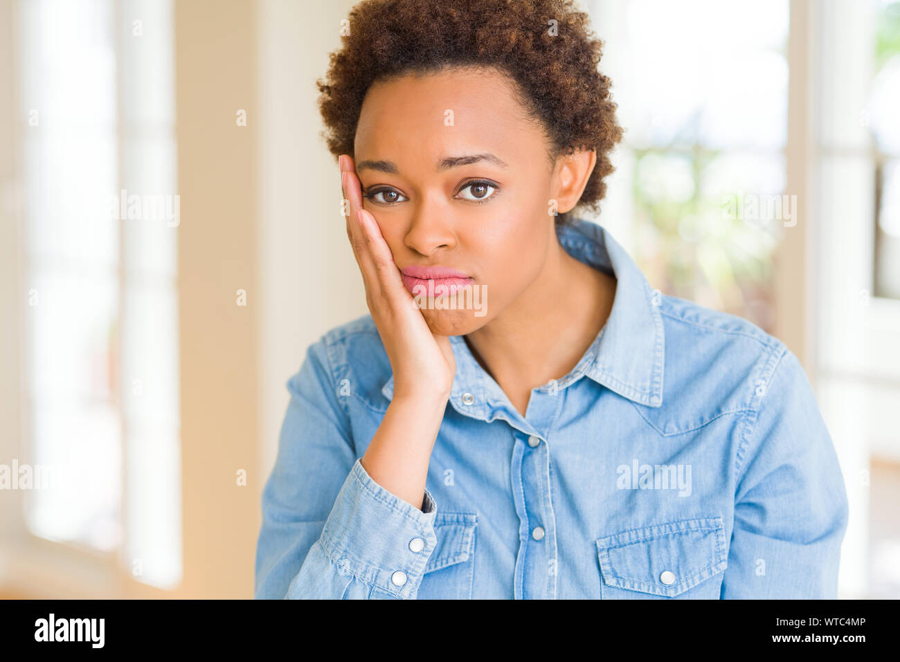 Young beautiful african american woman thinking looking tired and bored ...