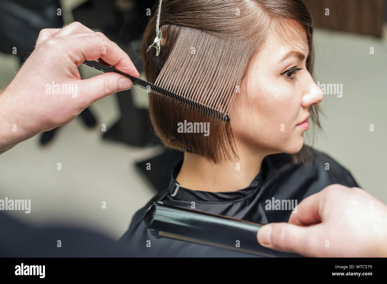 Professional hairdresser combing with a comb short hair. Hair salon. Woman  haircut. Cutting Stock Photo - Alamy