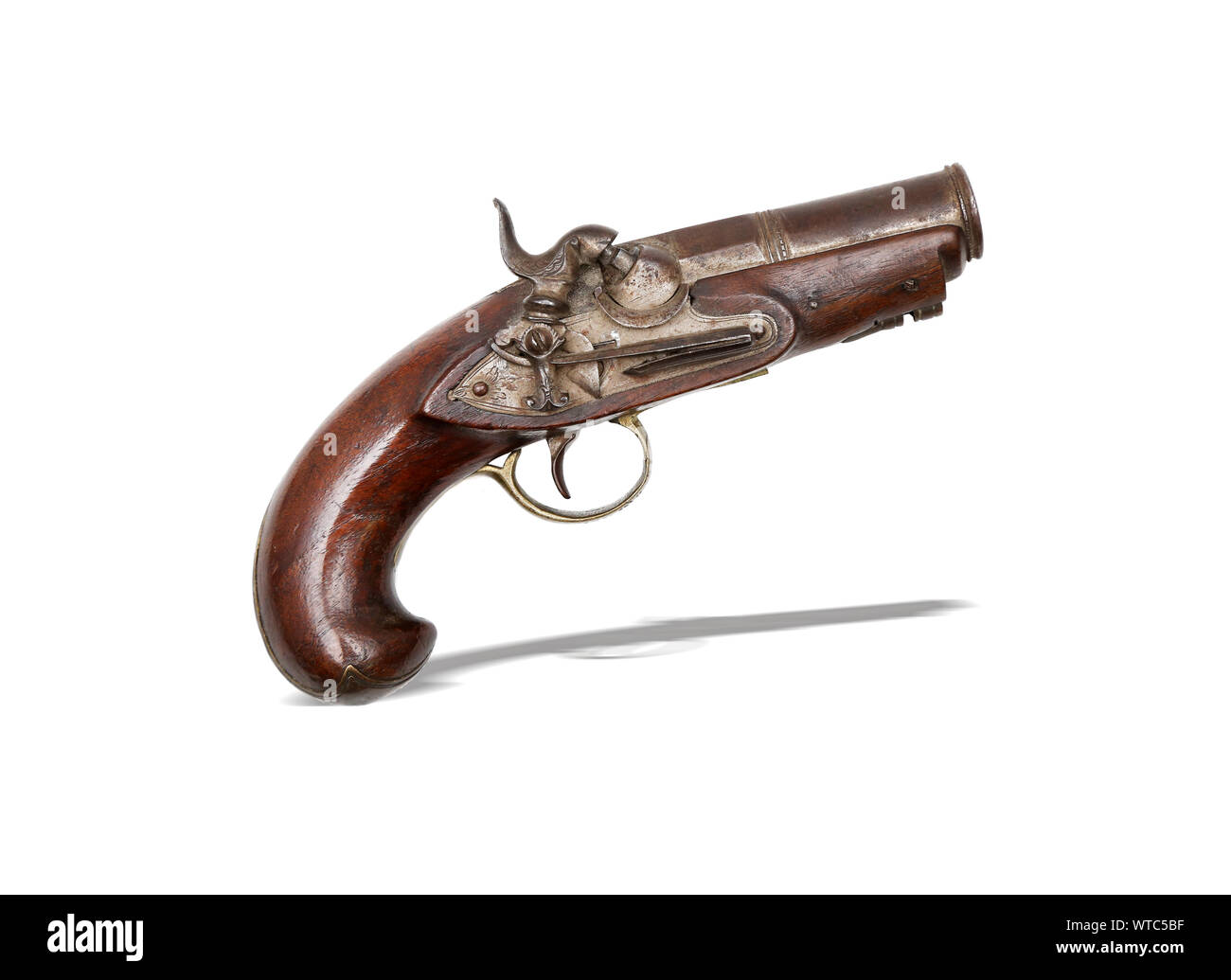 19th century Spanish percussion pistol with smooth bore. Wooden stock with engraved brass mounts. Pin-fastened barrel. Nicely engraved lock plates. Stock Photo