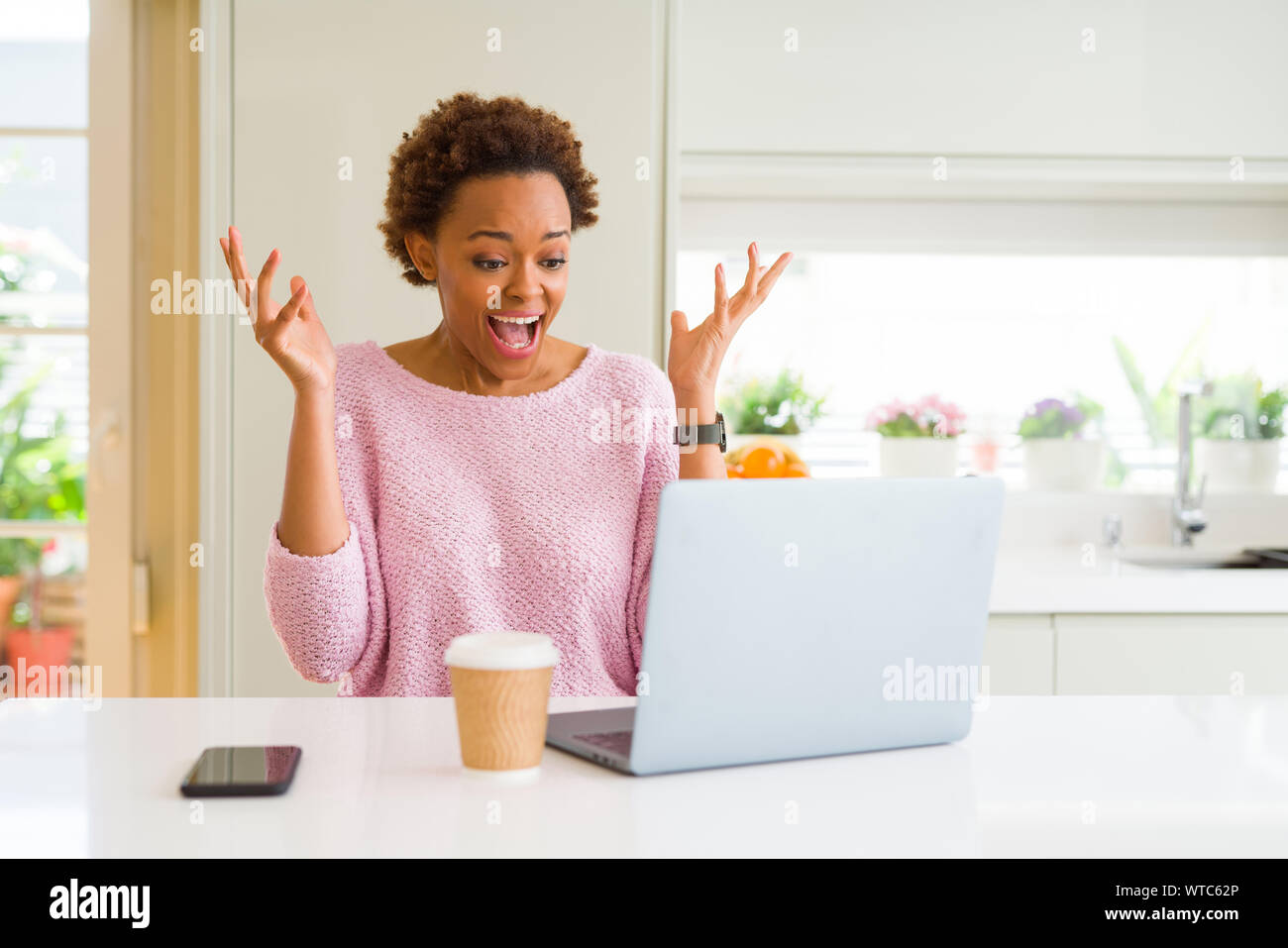 Young african american woman working using computer laptop celebrating ...
