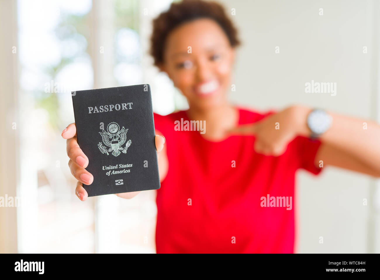 Young african american woman holding passport of United States of ...
