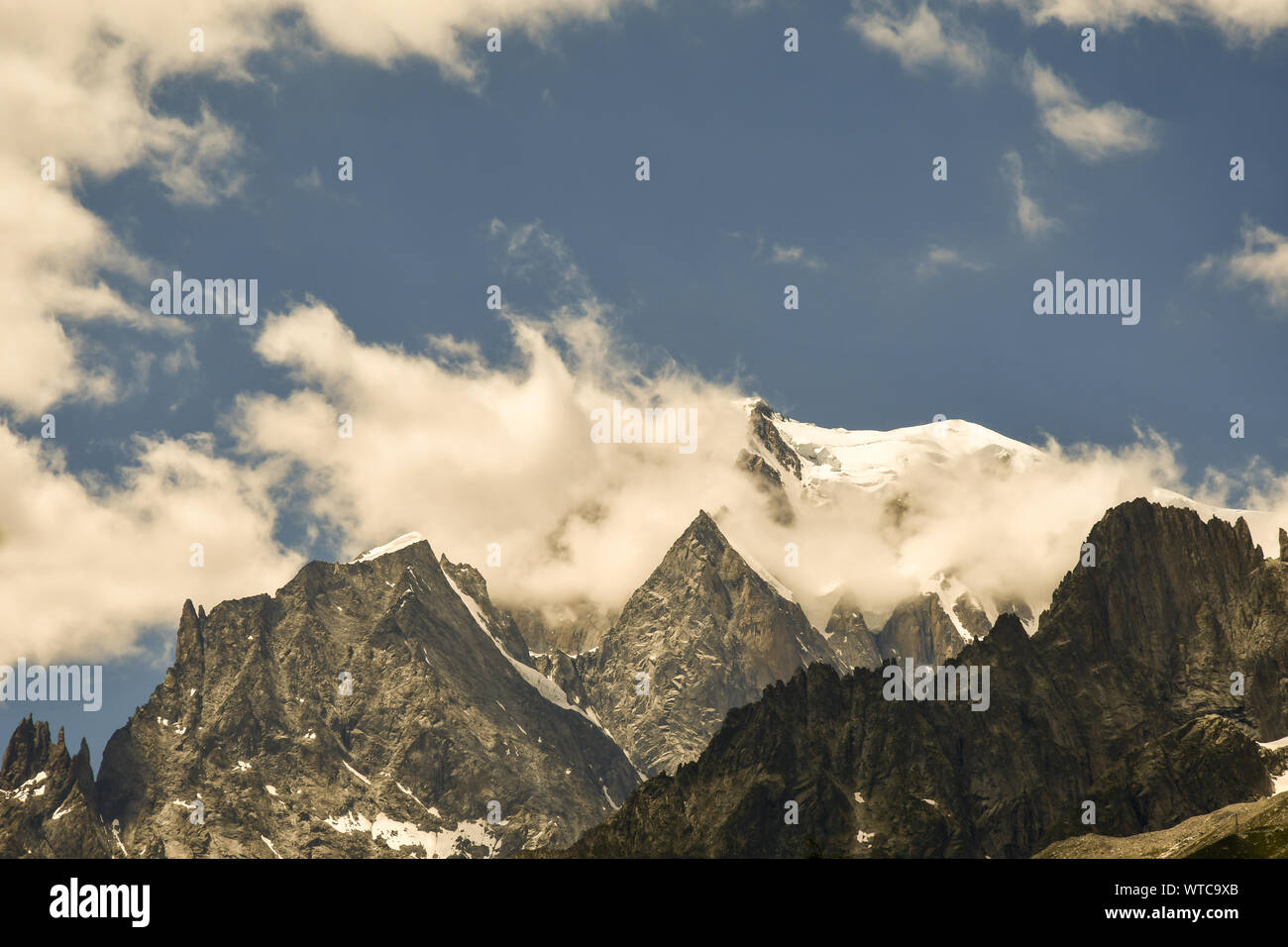 Tops of the Mont Blanc massif with the Grandes Jorasses mountain peaks and the snowcapped summit of Mont Blanc in summer, Courmayeur, Aosta, Italy Stock Photo