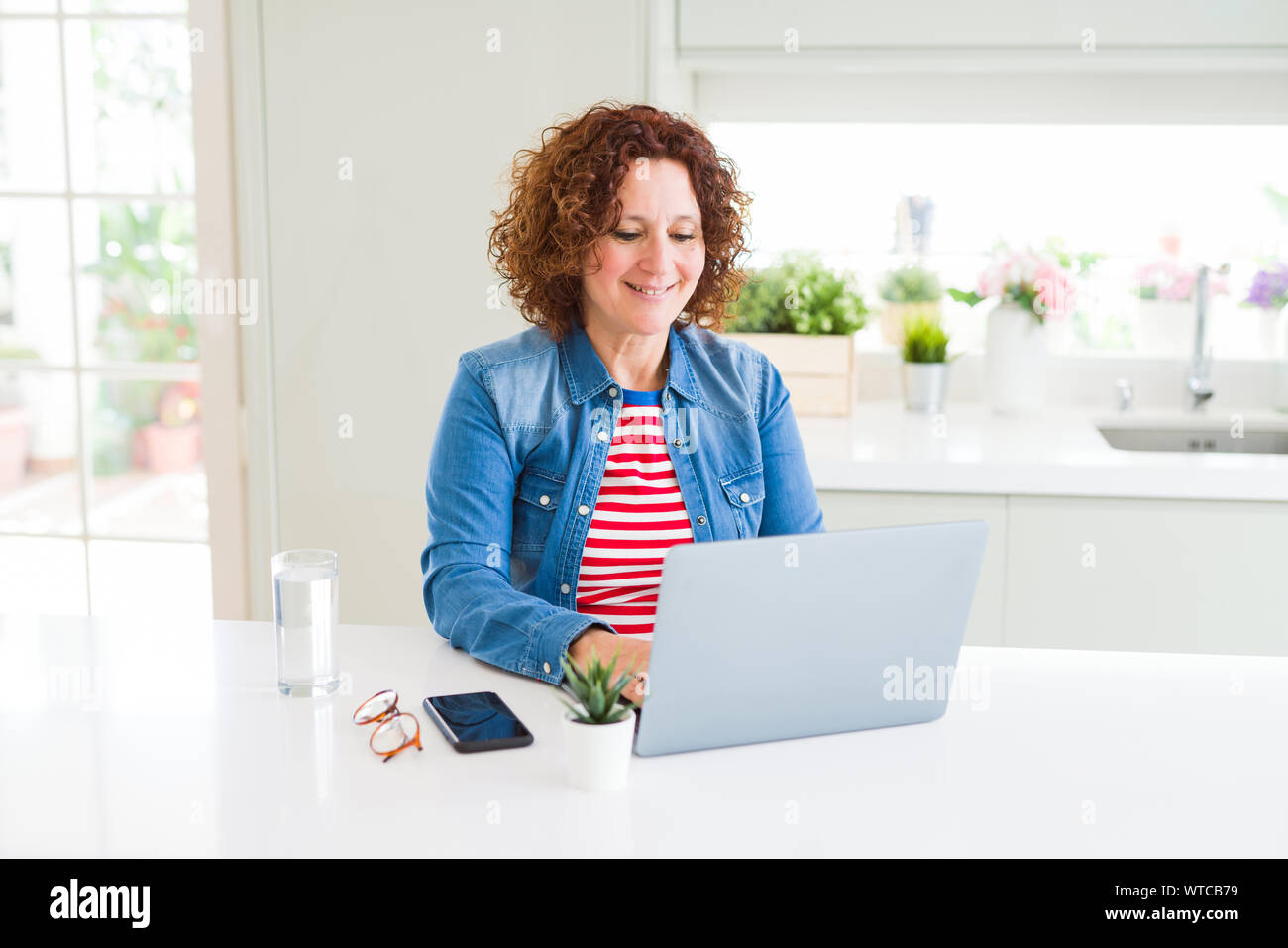 Senior woman working using computer laptop with a happy face standing ...