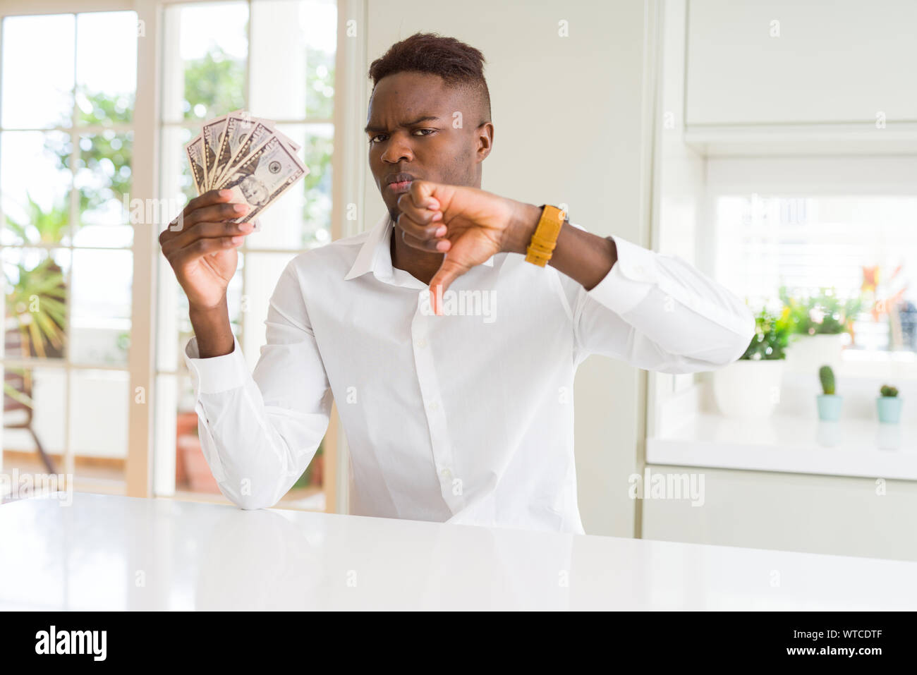 African american man holding fifty dollars bank notes with angry face ...