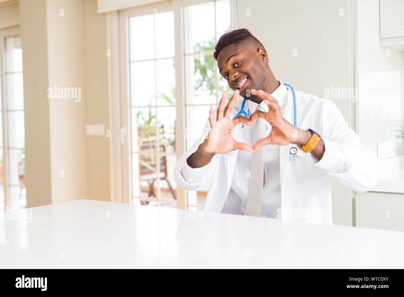 African american doctor man at the clinic smiling in love showing heart ...