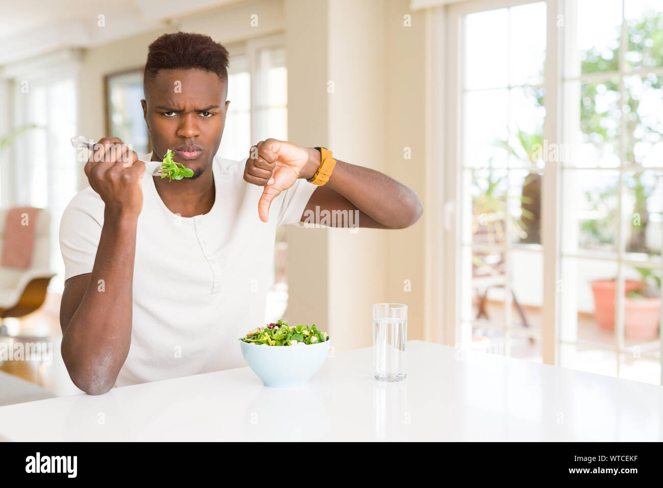 African American Man Eating Fresh Healthy Salad With Angry Face Negative Sign Showing Dislike 