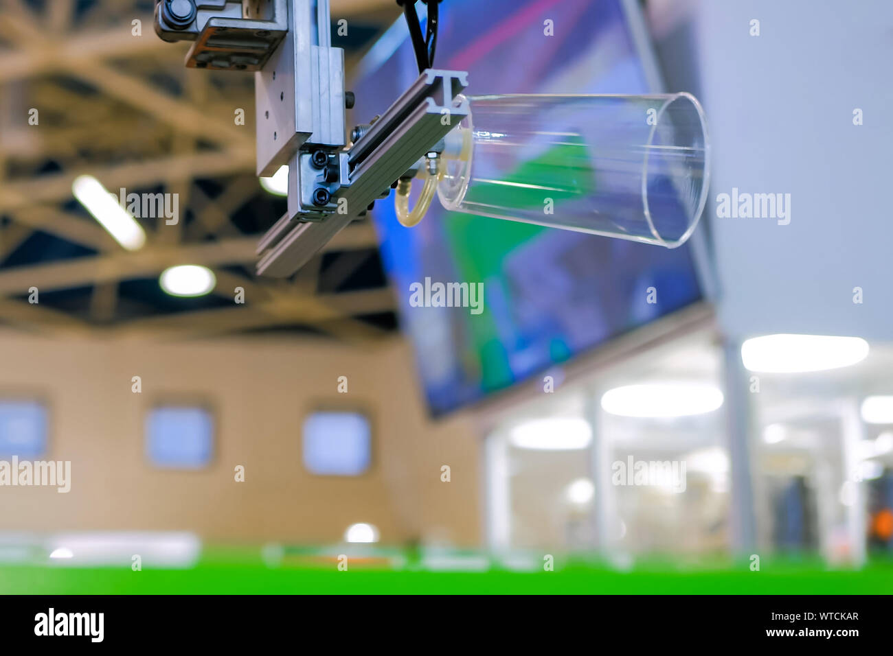 Automatic robotic arm manipulator with suction cups moves plastic clear cup Stock Photo