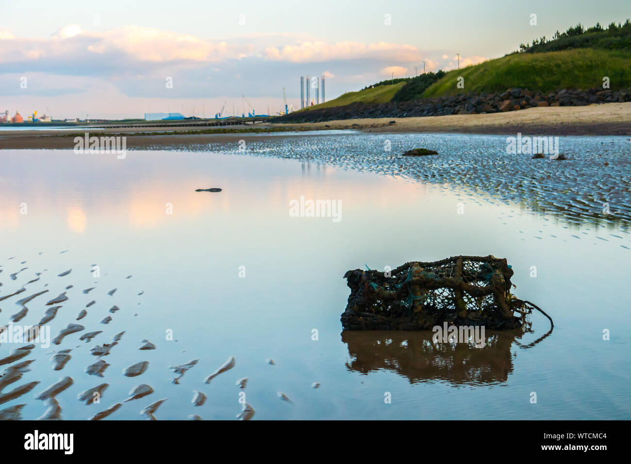 An Abandoned Lobster Pot in a Shallow Pool at Cambois Beach, Northumberland Stock Photo