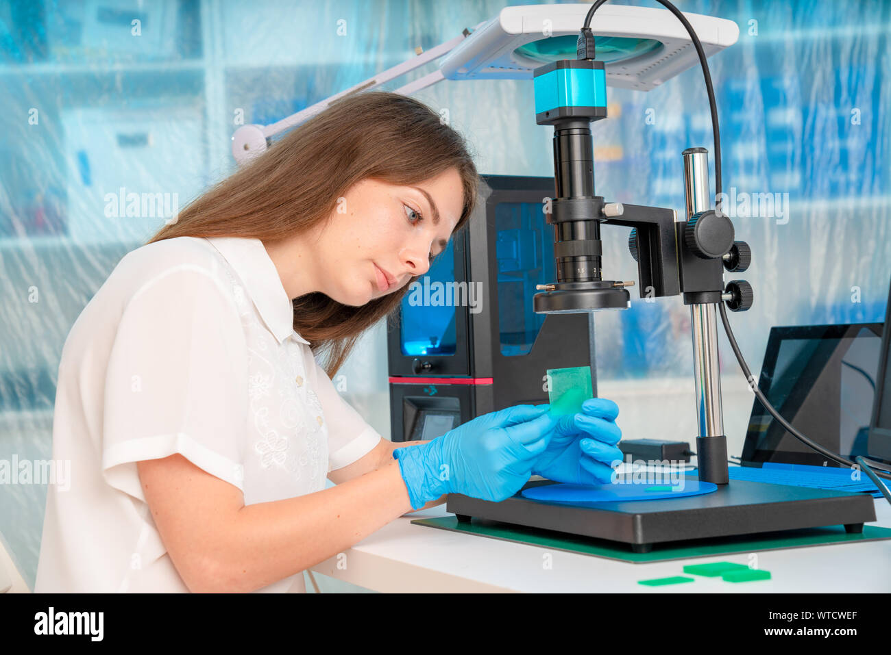 Woman worker in control of Resin LCD / DLP / SLA 3D Printer in technology lab Stock Photo