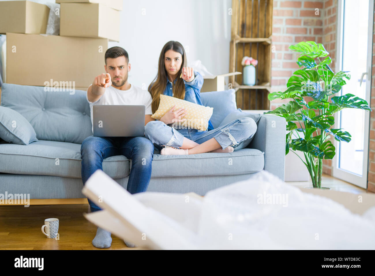 Young beautiful couple relaxing sitting on the sofa of new house using ...