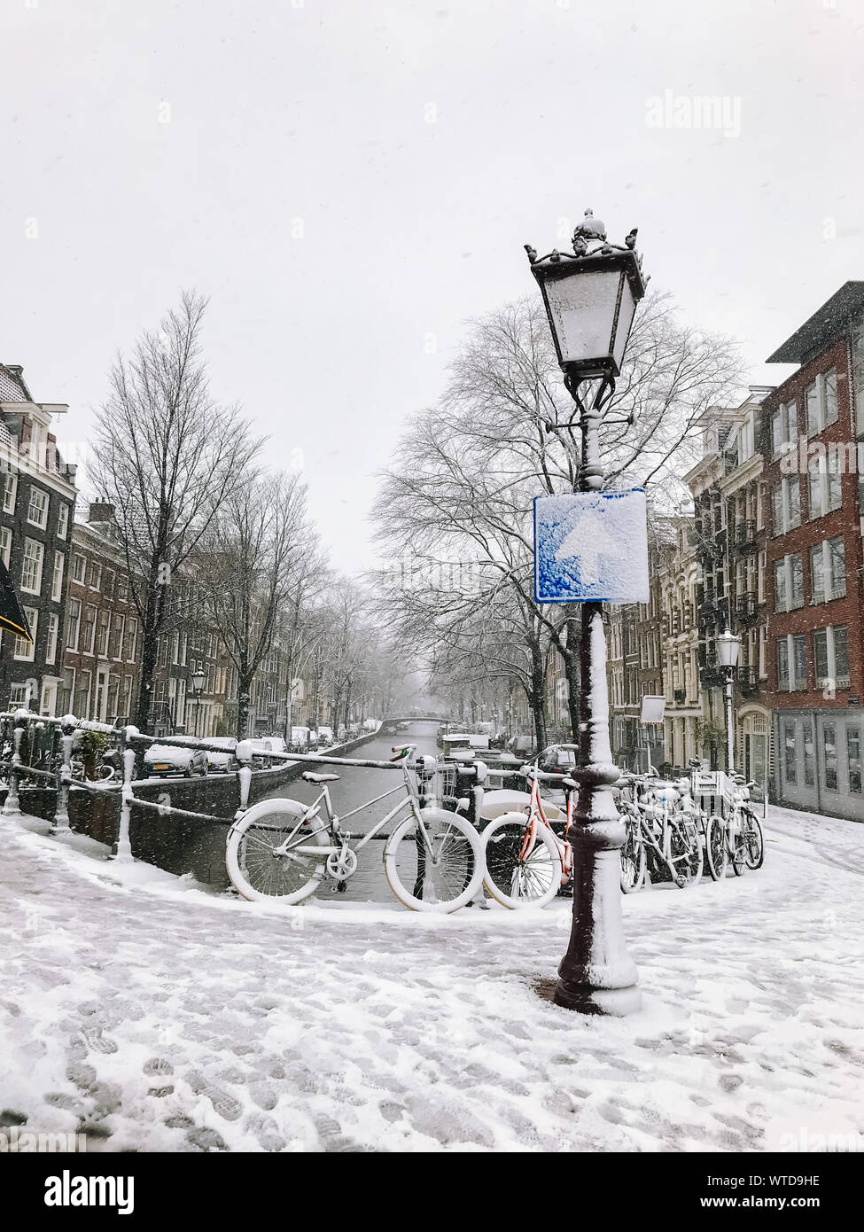 Snowy bicycles on the bridge in the city center Amsterdam Netherlands ...