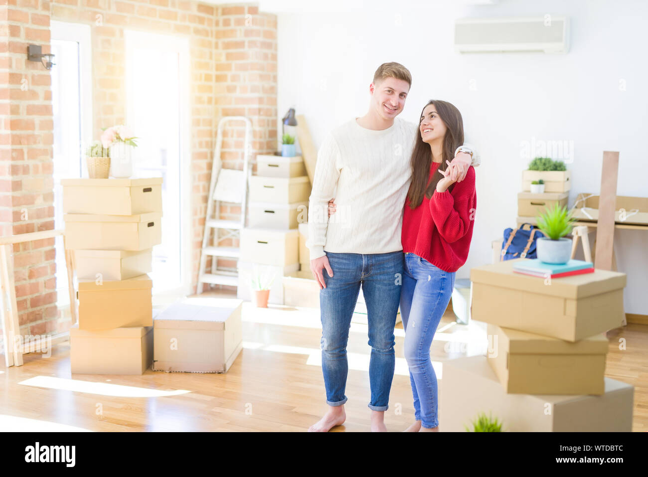 Beautiful young couple moving to a new home, standing on new aparment ...