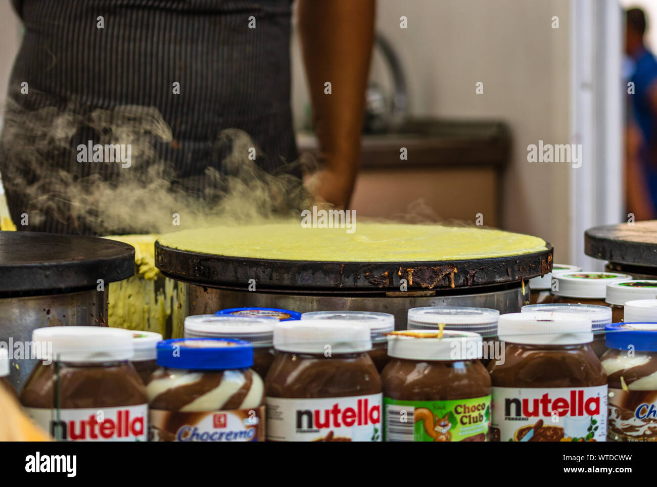 Chefs making and selling crepes, pancakes at a food festival in