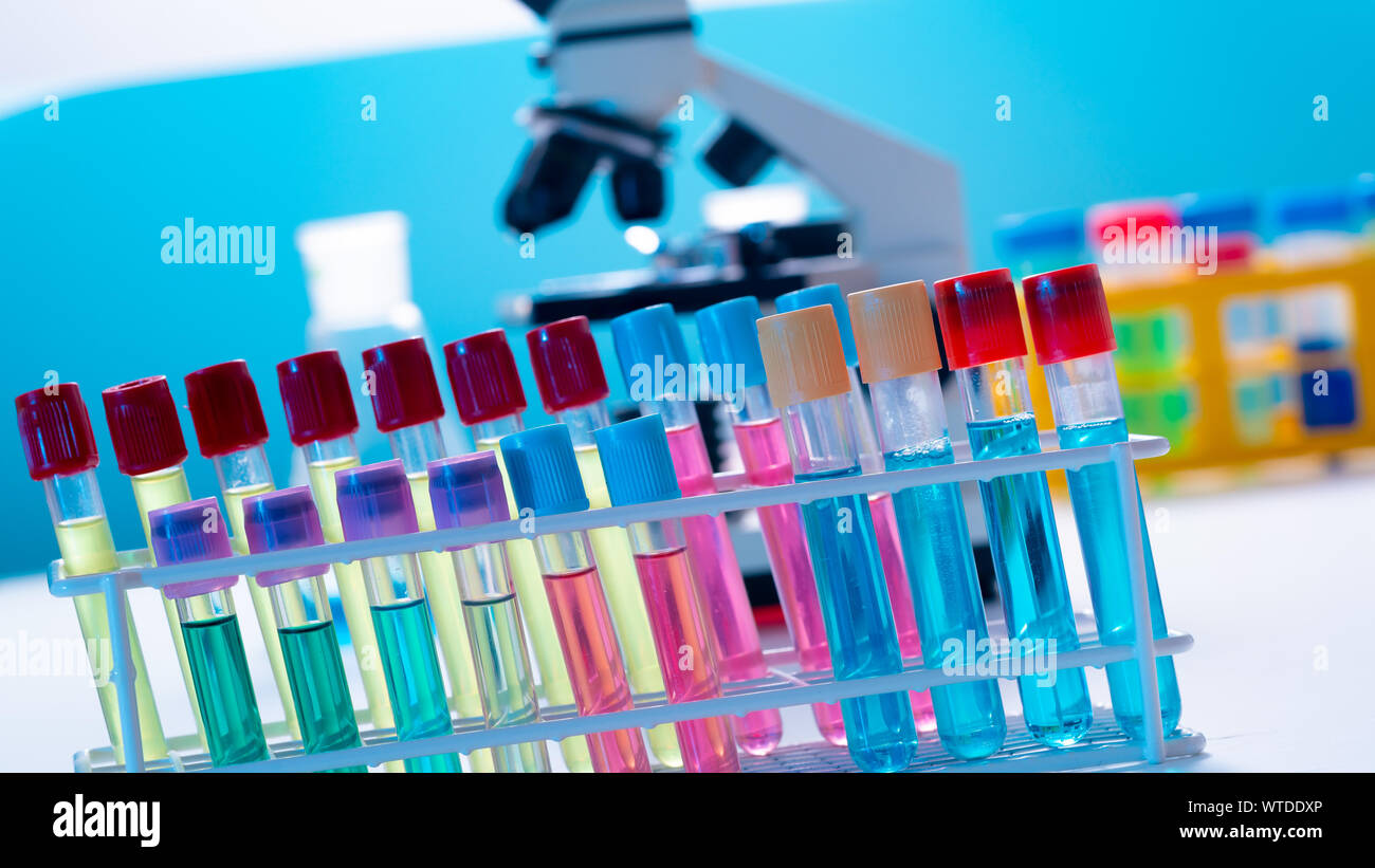 Microscope and test tubes on laboratoy table Stock Photo - Alamy