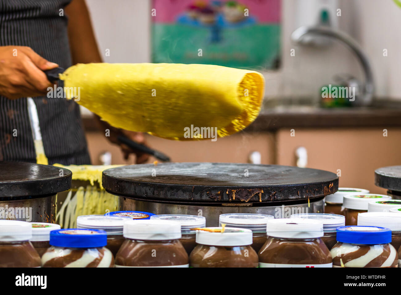 Chefs making and selling crepes, pancakes at a food festival in