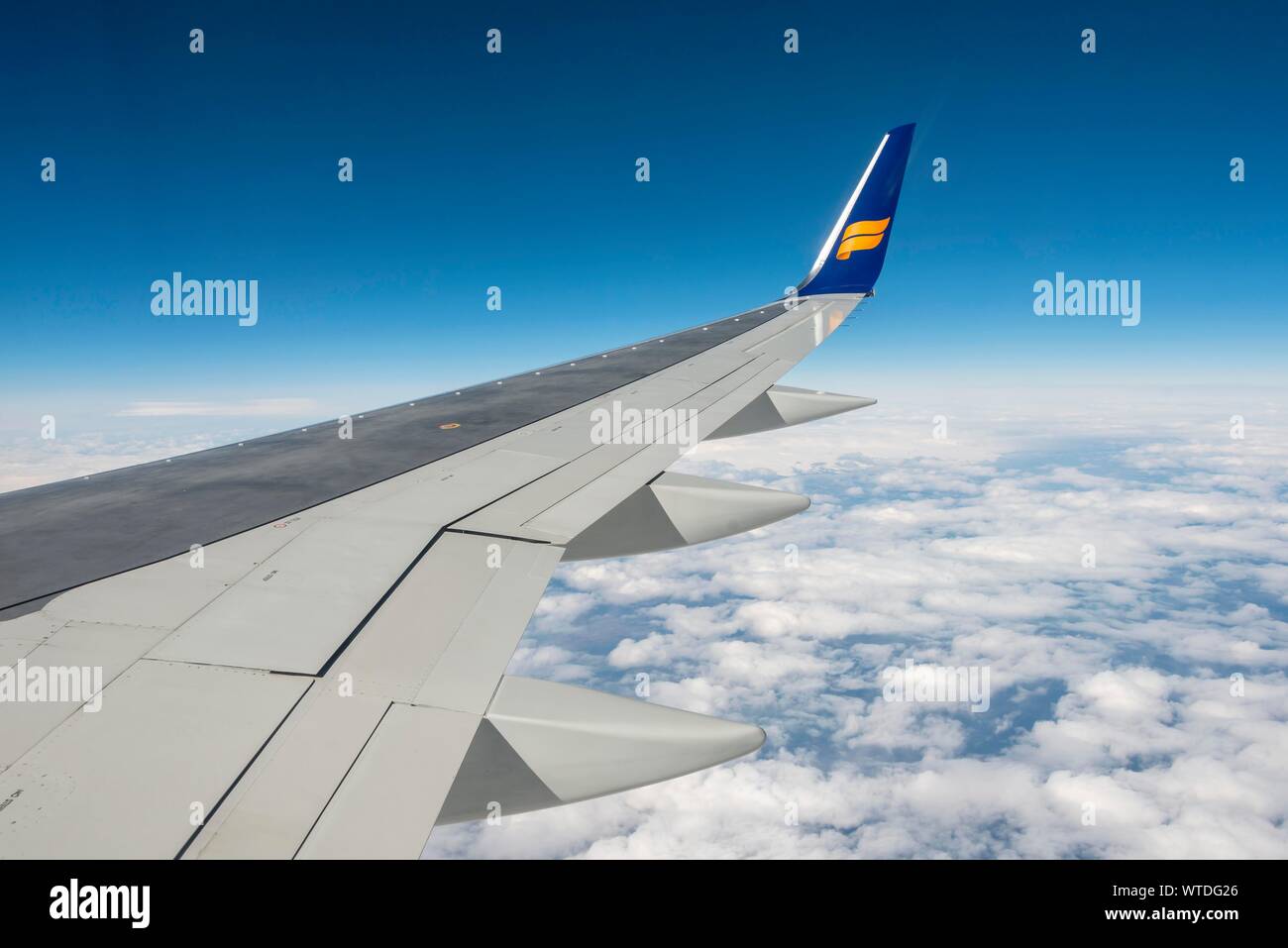 Wing, aircraft from IcelandAir over cloudy sky, Iceland Stock Photo