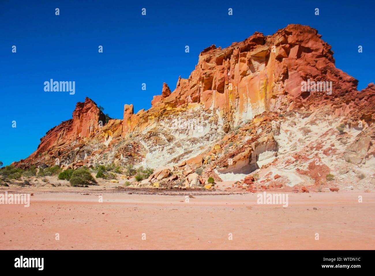 Low Angle View Of Rocky Mountains Against Clear Blue Sky At Rainbow Valley Stock Photo