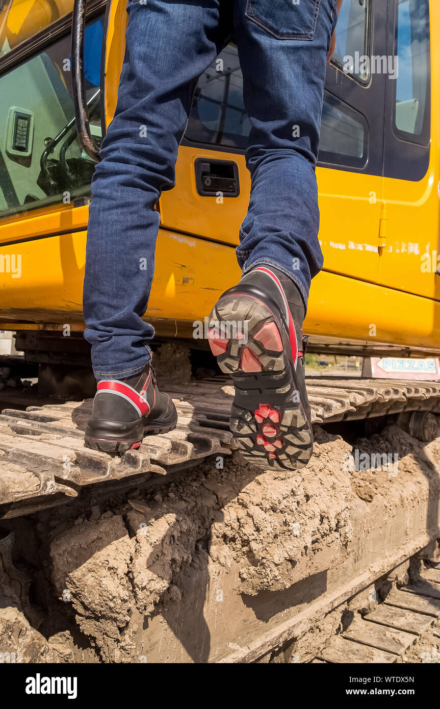 Construction worker wearing safety shoes with strong sole driving