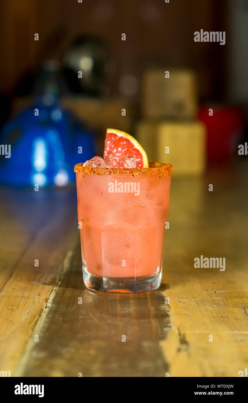 grapefruit and chili powder cocktail close up at the table of a rustic