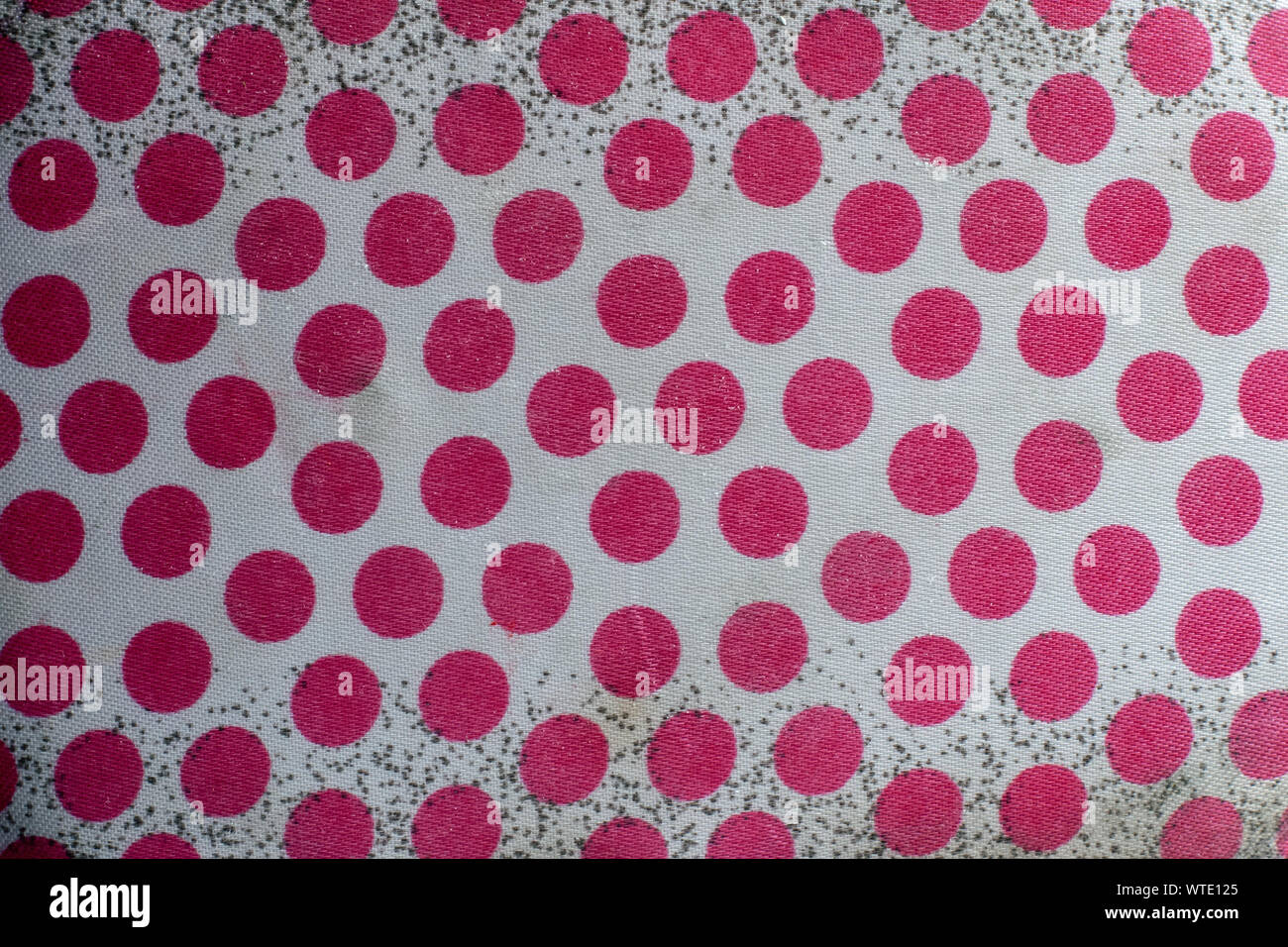 The texture of the old white fabric with red polka dots and black dots on a white background. A lot of red circles. Stock Photo