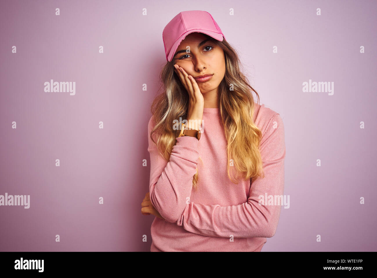 Young beautiful woman wearing cap over pink isolated background thinking looking tired and bored with depression problems with crossed arms. Stock Photo
