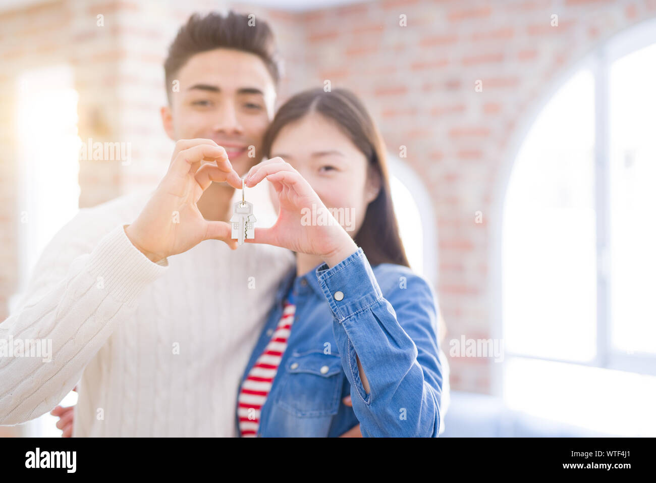 Young asian couple holding keys of new house, smiling happy and excited ...