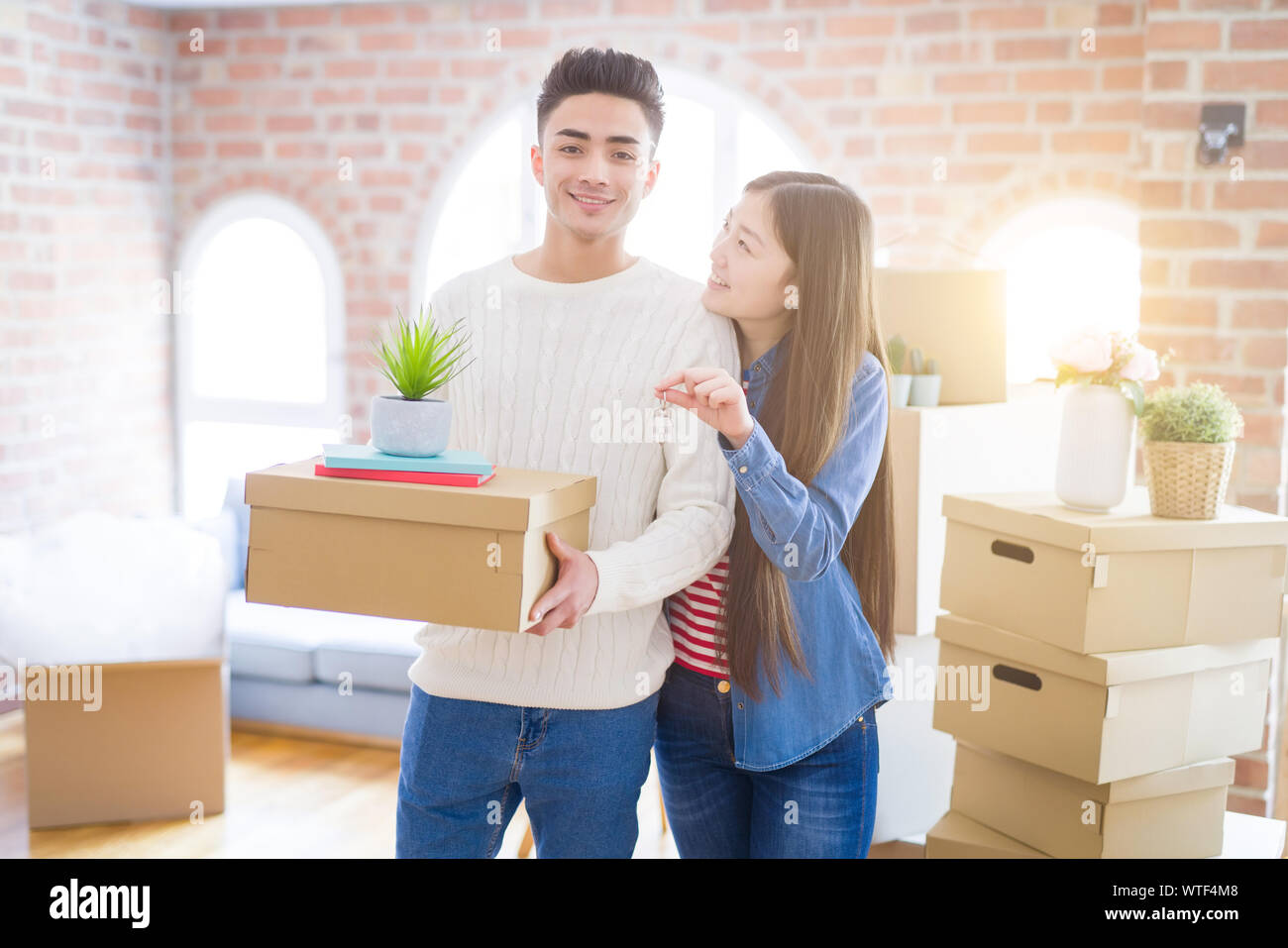 Young asian couple holding keys of new house, smiling happy and excited ...