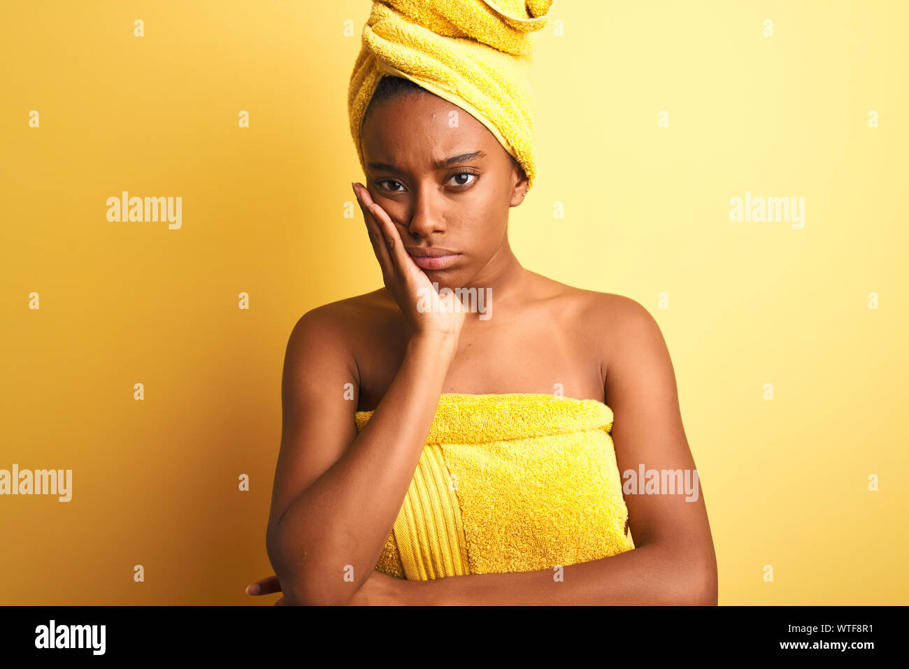 African american woman wearing towel after shower standing over isolated  yellow background thinking looking tired and bored with depression problems  w Stock Photo - Alamy