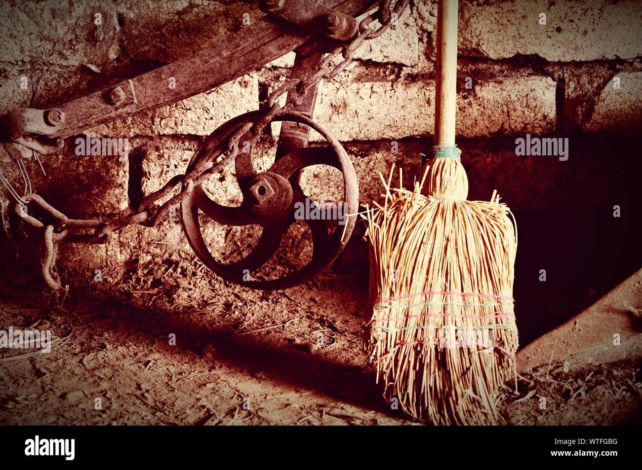 Damaged Sweep By Rusty Wheel In Storehouse Stock Photo