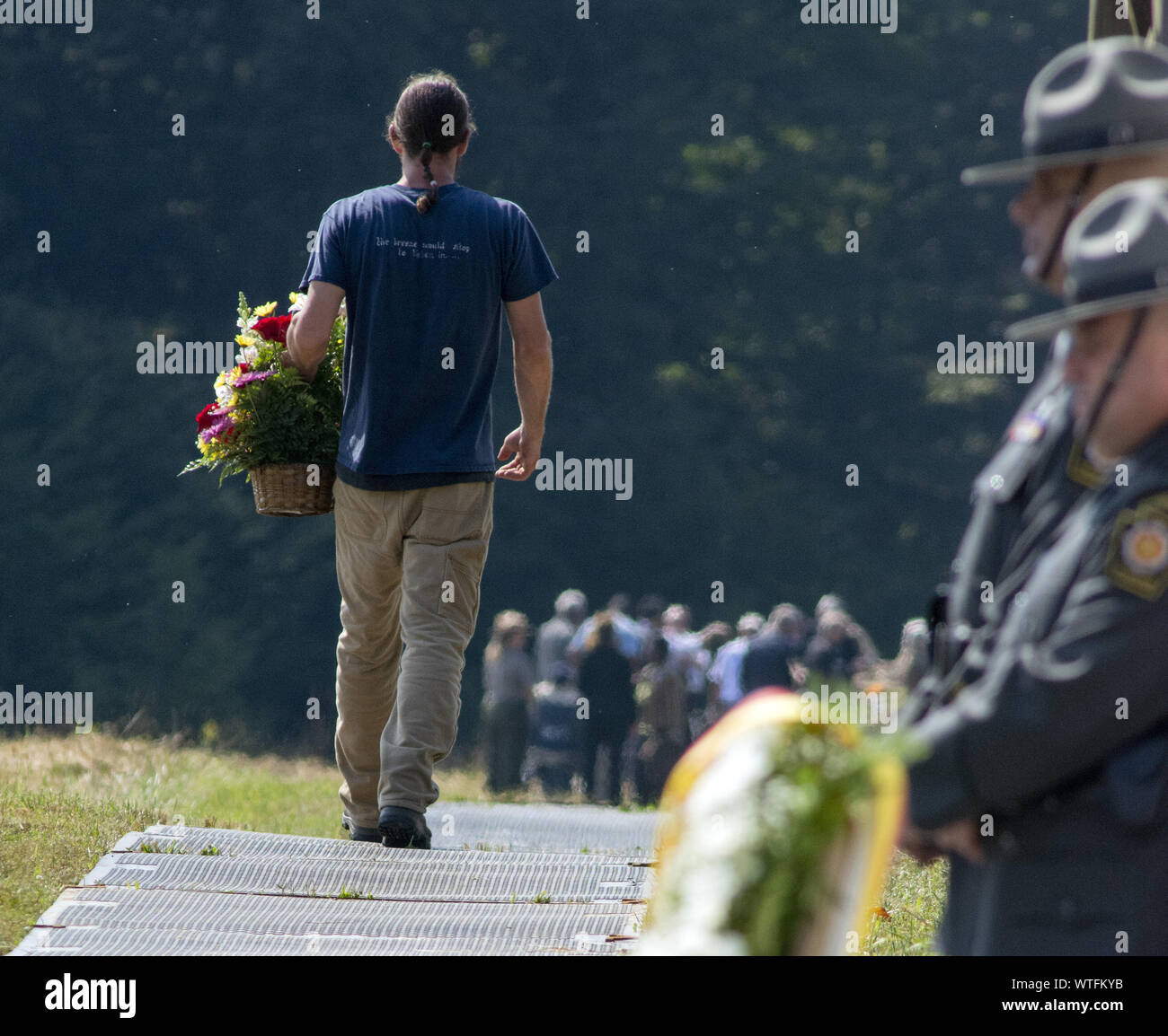 Pittsburgh, United States. 11th Sep, 2019. A family member of a victim carries a basket of flower to the boulder that marks the crash site of Flight 93 on the 18th observance of the terrorist attack at the Flight 93 National Memorial near Shanksville, Pennsylvania on Wednesday September 11, 2019 . Photo by Archie Carpenter/UPI Credit: UPI/Alamy Live News Stock Photo
