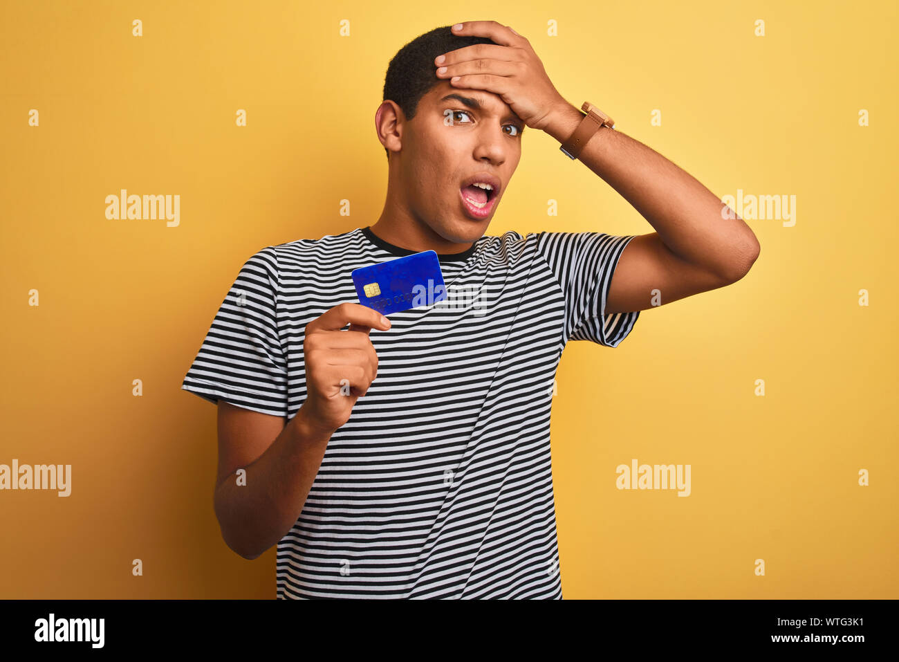 Young handsome arab man holding credit card standing over isolated ...