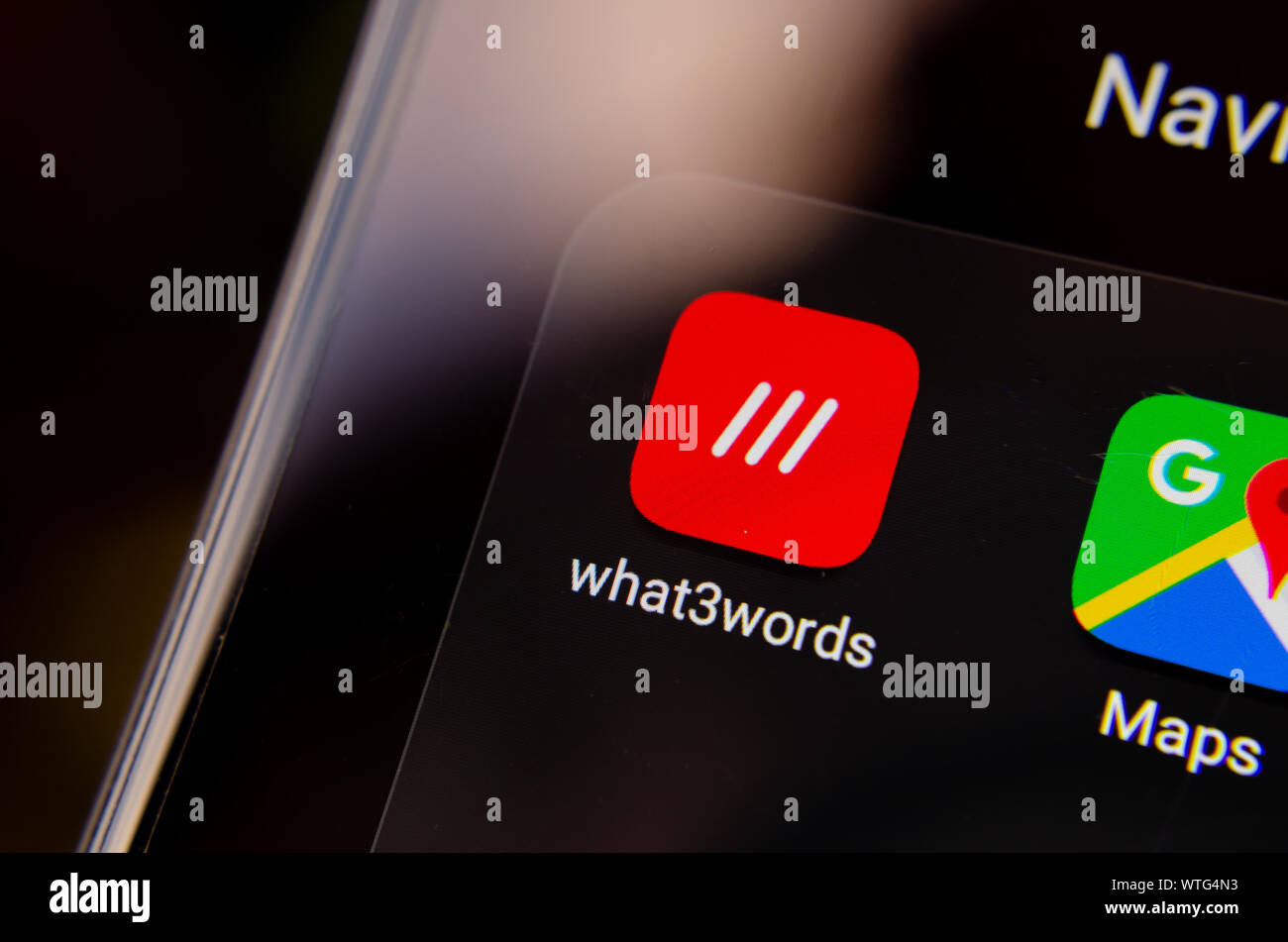 What3words app icon on the smartphone screen in the section of navigation apps, next to Google Maps. What 3 words is an innovative geocoding system. Stock Photo