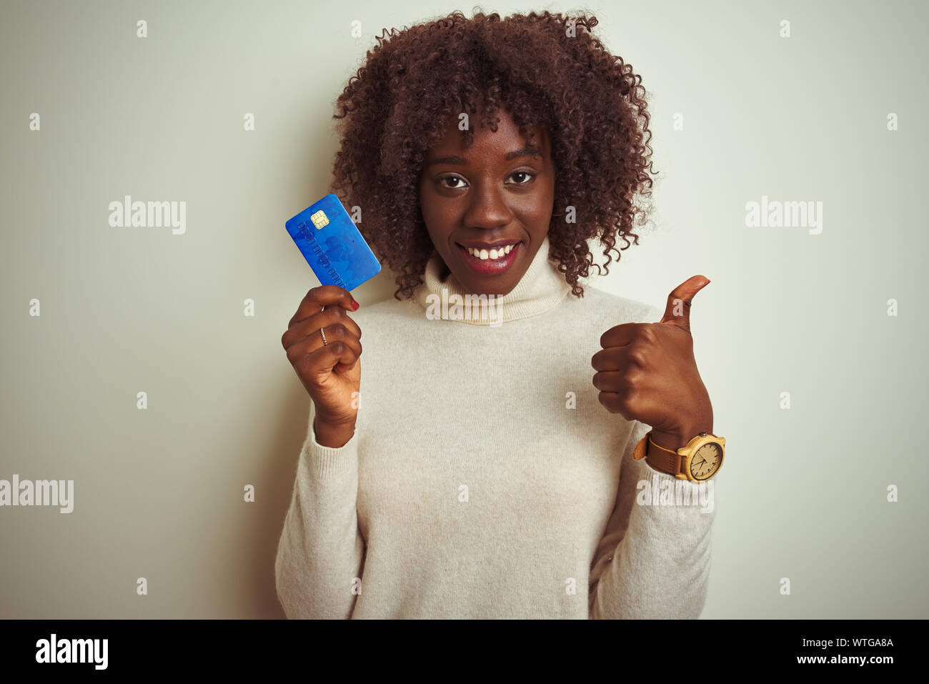 Young african afro woman holding credit card standing over isolated Young african afro woman holding credit card standing over isolated