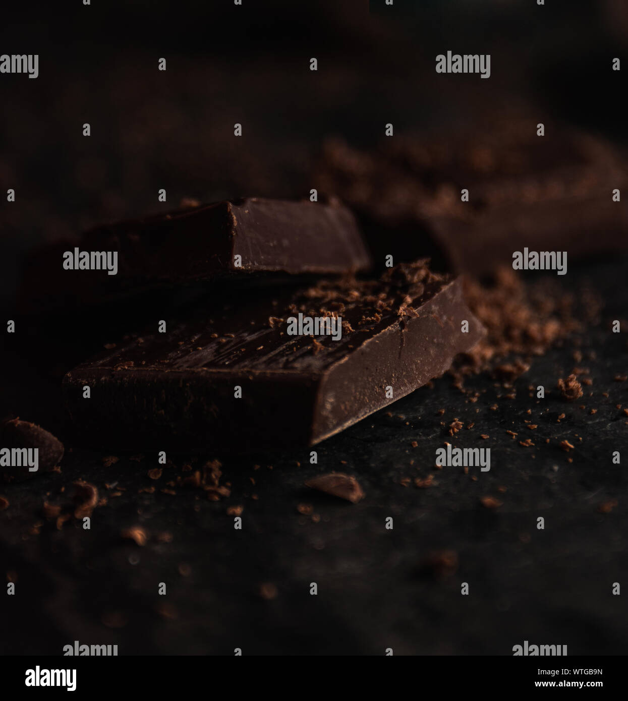 Dark bitter chocolate close up over a wood table Stock Photo - Alamy