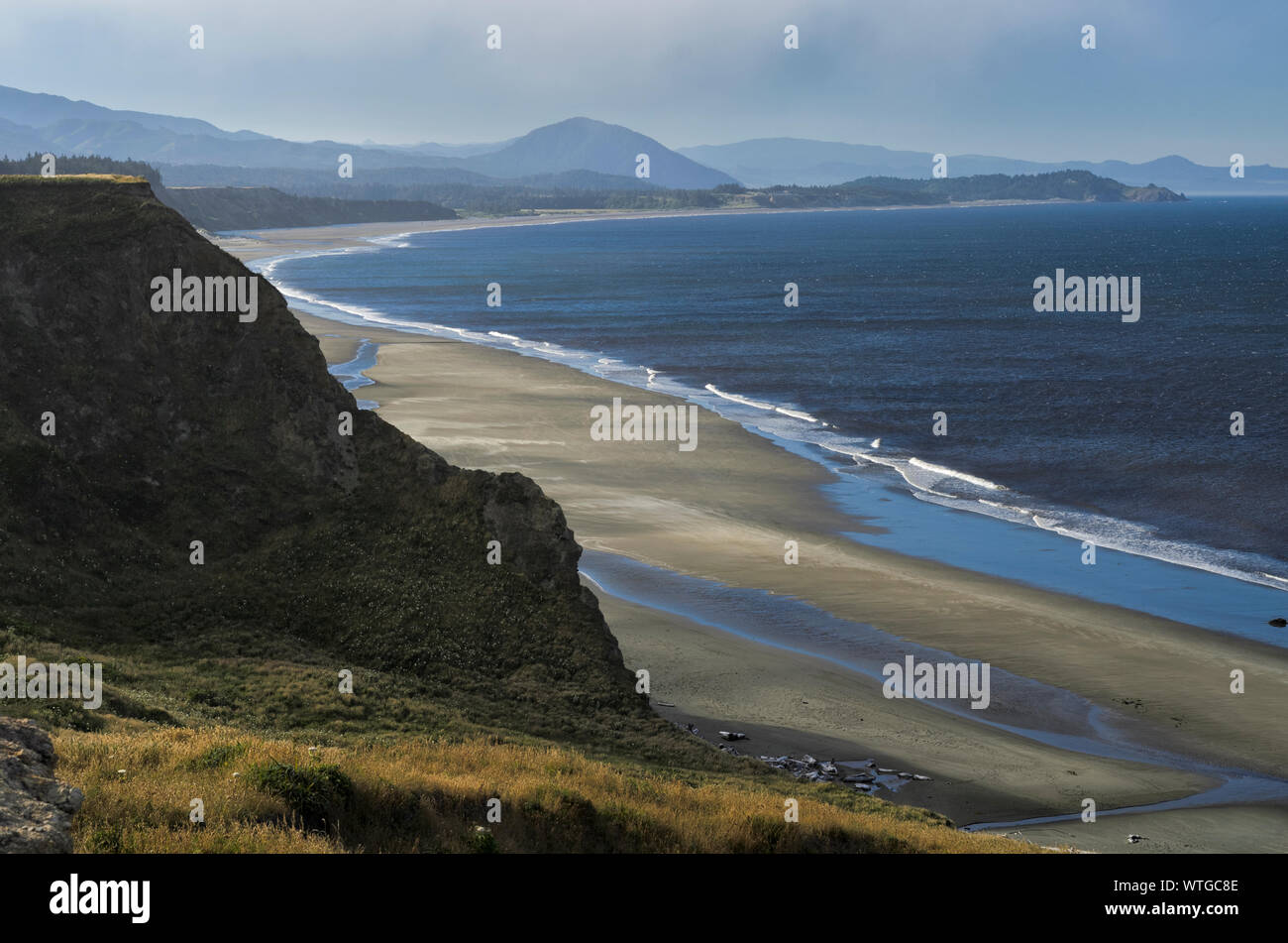 The beach at Cape Blanco State Park, lined by cliffs and sea stacks, extends from Cape Blanco to Port Orford. Stock Photo