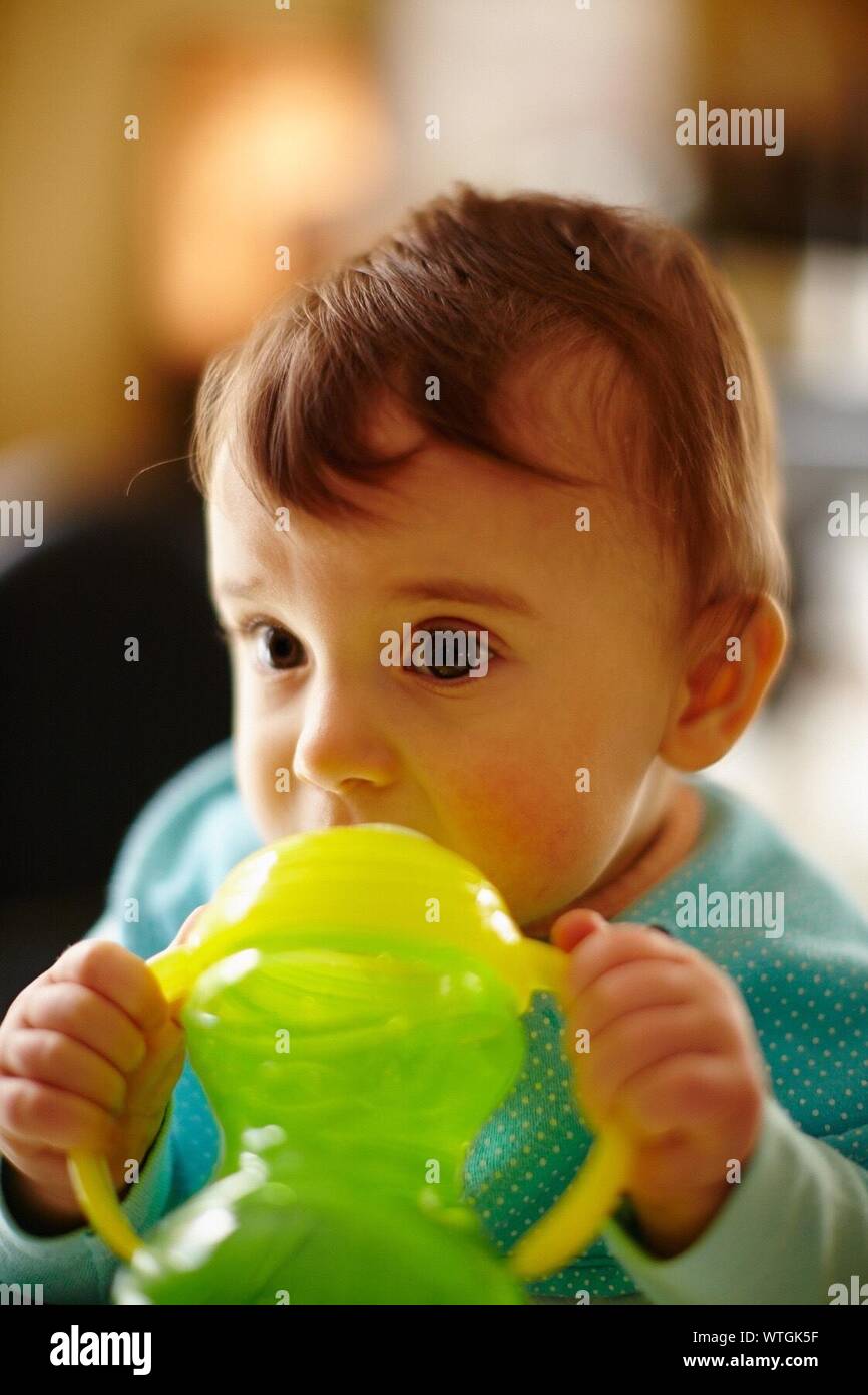 Small Baby Holding Water Bottle To Mouth Stock Photo