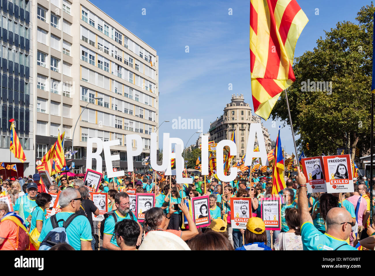 People holding 'Republica' word and banners claiming freedom for some exiled and prisoner catalan politicians during a protest in 'La Diada' Stock Photo