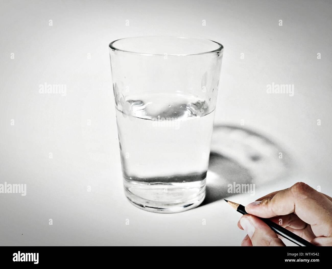 Person Holding Pencil By Glass Of Drinking Water Stock Photo Alamy