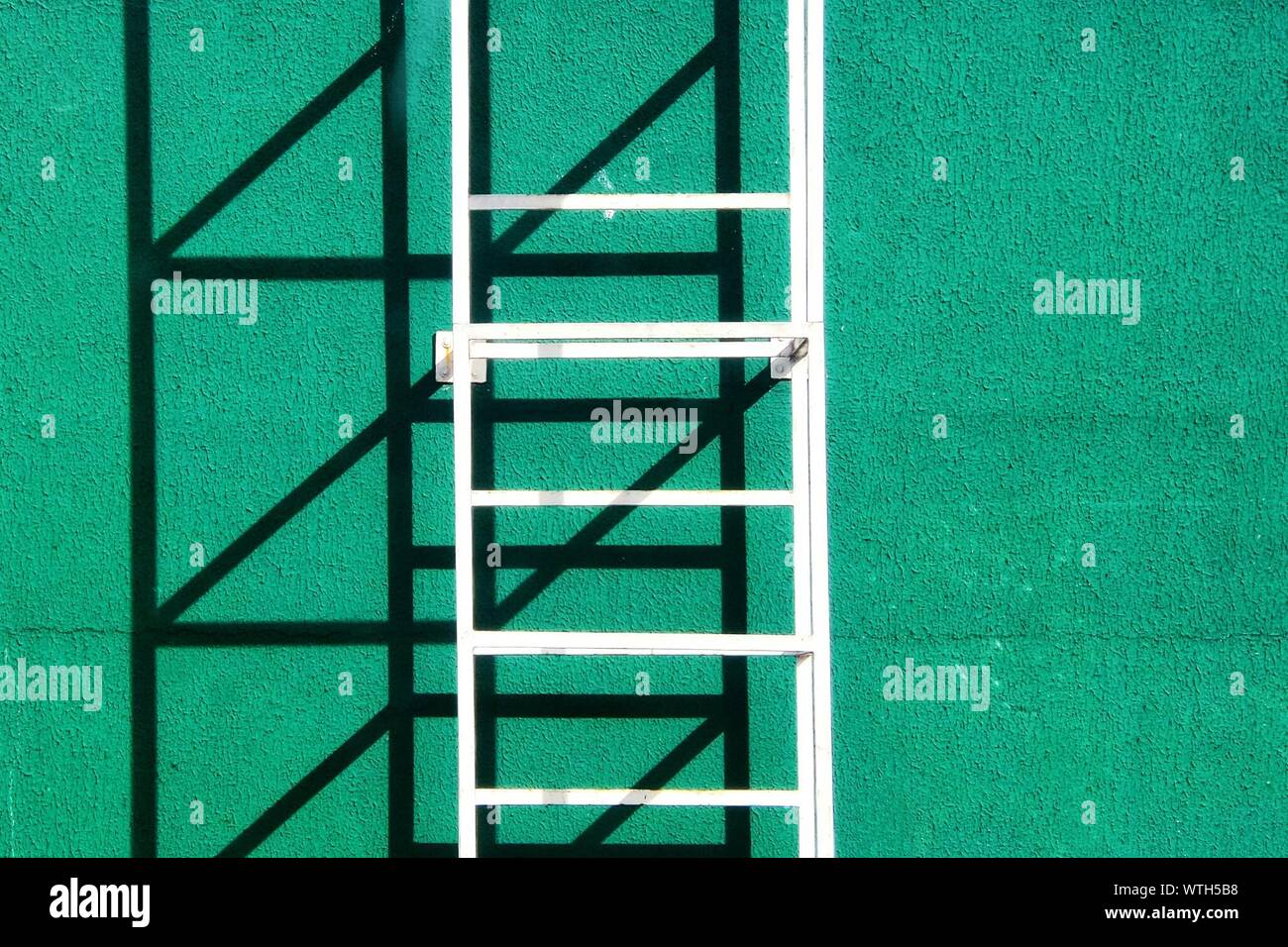 Closeup Of Metal Ladder Against Green Stucco Wall Stock Photo Alamy